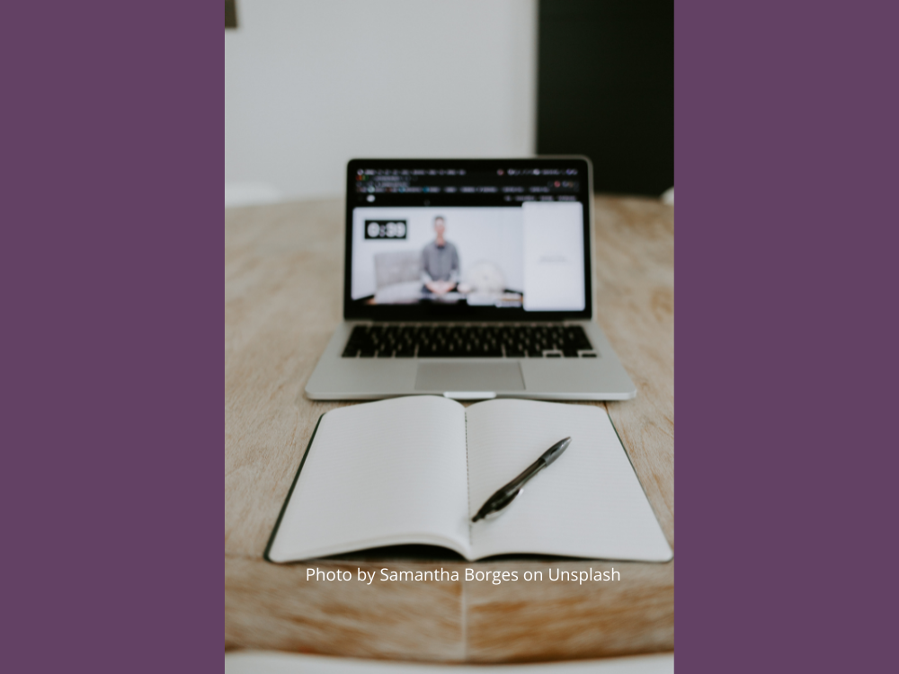 photo of open laptop and open notebook with pen